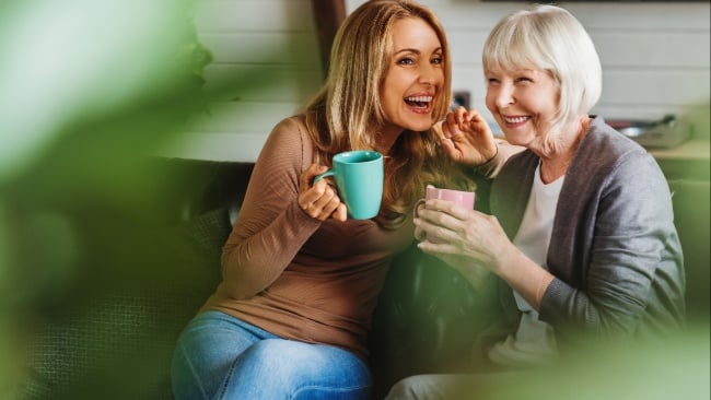 Happy mother with adult daughter talking